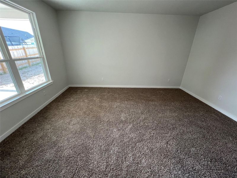Unfurnished room featuring dark carpet and baseboards Unfurnished room featuring dark carpet and baseboards