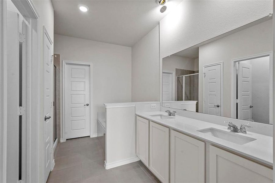 Primary Bathroom featuring vanity, tile patterned flooring, and an enclosed shower