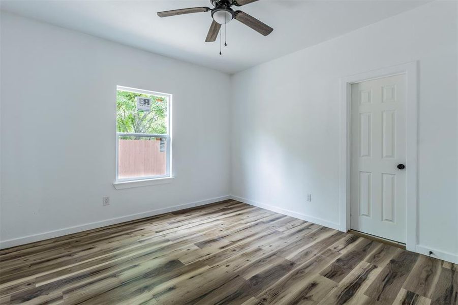 Empty room with wood finished floors, ceiling fan, and baseboards Empty room with wood finished floors, ceiling fan, and baseboards