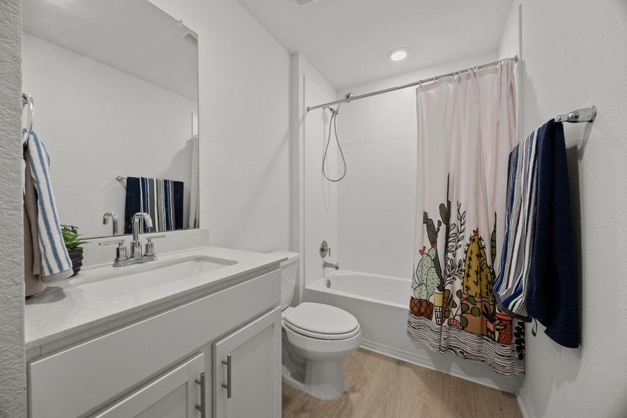Full bathroom featuring vanity, light wood-style floors, and shower / bathtub combination with curtain