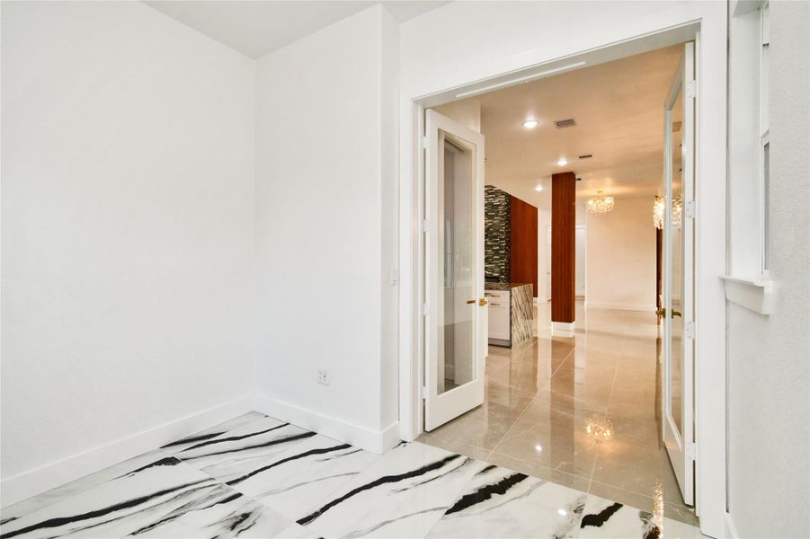 A versatile room featuring dramatic black-and-white marbled flooring, perfect for a private office or creative studio.
