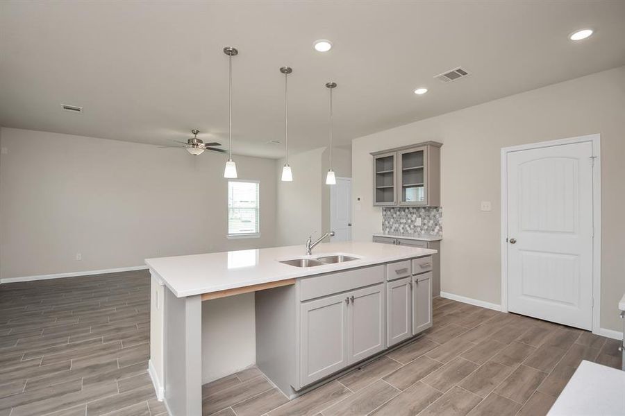 The expansive granite kitchen island offer endless space for culinary adventures, while the seamless flow into the living area makes entertaining a breeze. Imagine hosting gatherings where friends and family mingle effortlessly, all within this bright and welcoming space. *This image is from another Saratoga Home with similar floor plan and finishes, not the Brittany floorplan.*