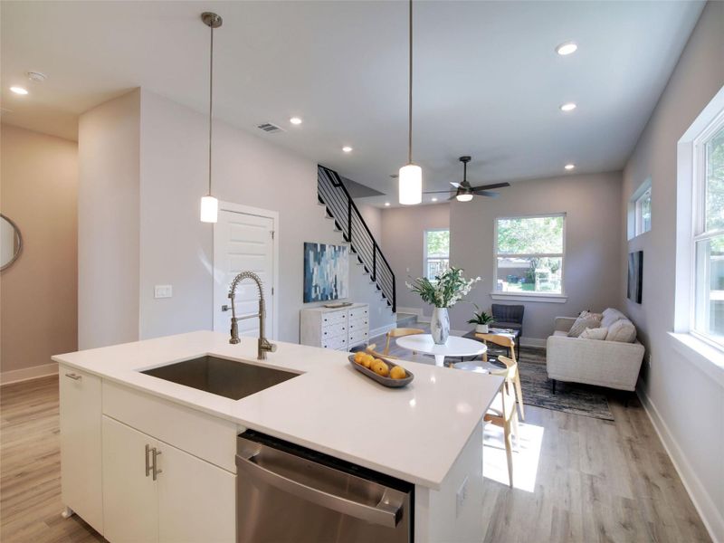 Kitchen featuring hanging light fixtures, dishwasher, white cabinets, a kitchen island with sink, and recessed lighting