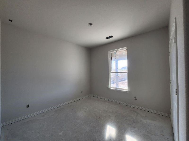 Empty room with concrete floors and baseboards