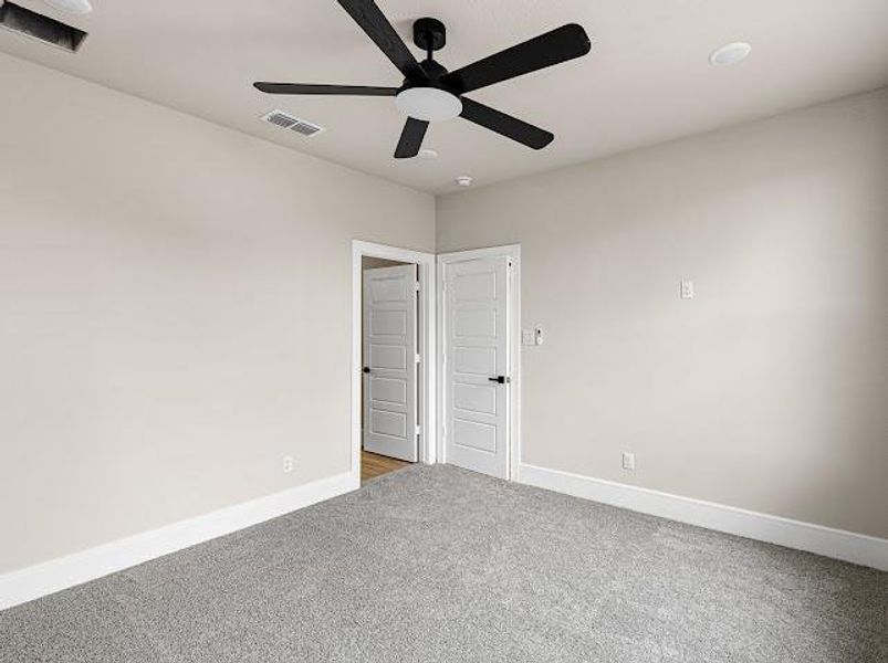 Carpeted spare room with baseboards and a ceiling fan Carpeted spare room with baseboards and a ceiling fan