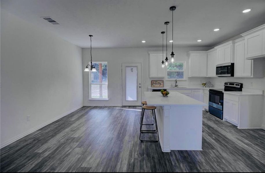 Kitchen with white cabinets, electric range, healthy amount of natural light, stainless steel microwave, and recessed lighting Kitchen with white cabinets, electric range, healthy amount of natural light, stainless steel microwave, and recessed lighting