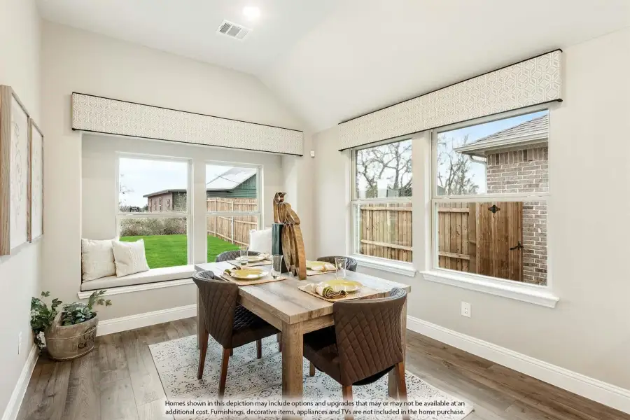 Dining area with wood table, built-in window seat, vaulted ceiling, and hardwood floors