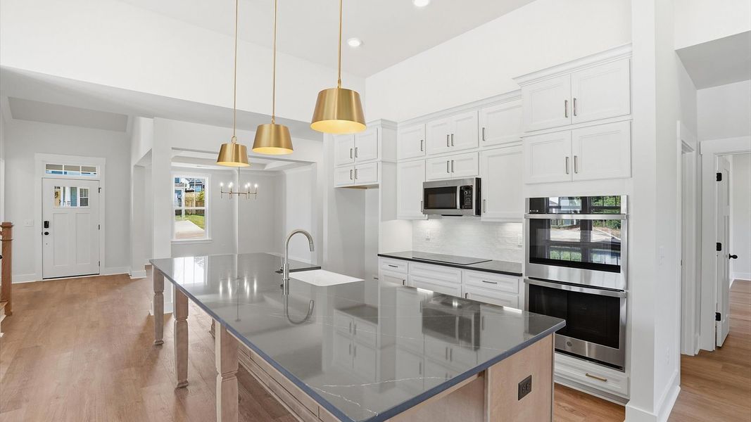 Exceptional kitchen featuring a spacious island, eye-catching pendant lights, and modern finishes at Pinebrook Exceptional kitchen featuring a spacious island, eye-catching pendant lights, and modern finishes at Pinebrook