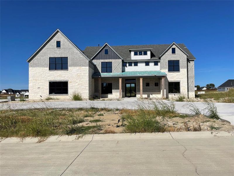 Modern farmhouse with a porch and stone siding