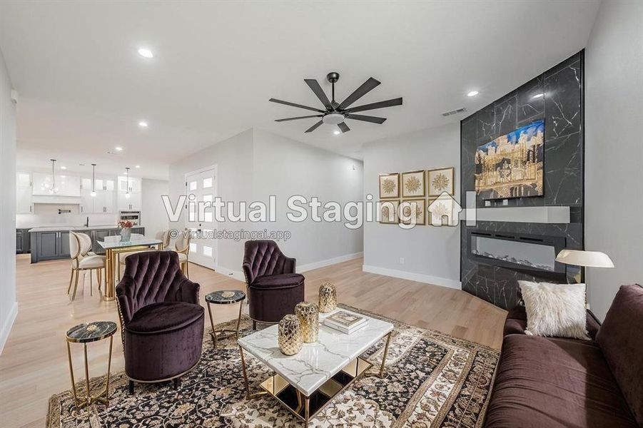 Living room with light wood-style floors, ceiling fan, recessed lighting, and a fireplace