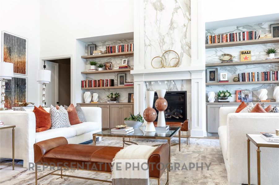 Living room with a towering ceiling, a fireplace, and built in features Living room with a towering ceiling, a fireplace, and built in features