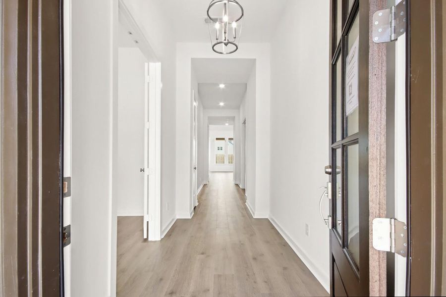 Bright entryway with vaulted feel and striking light fixture!