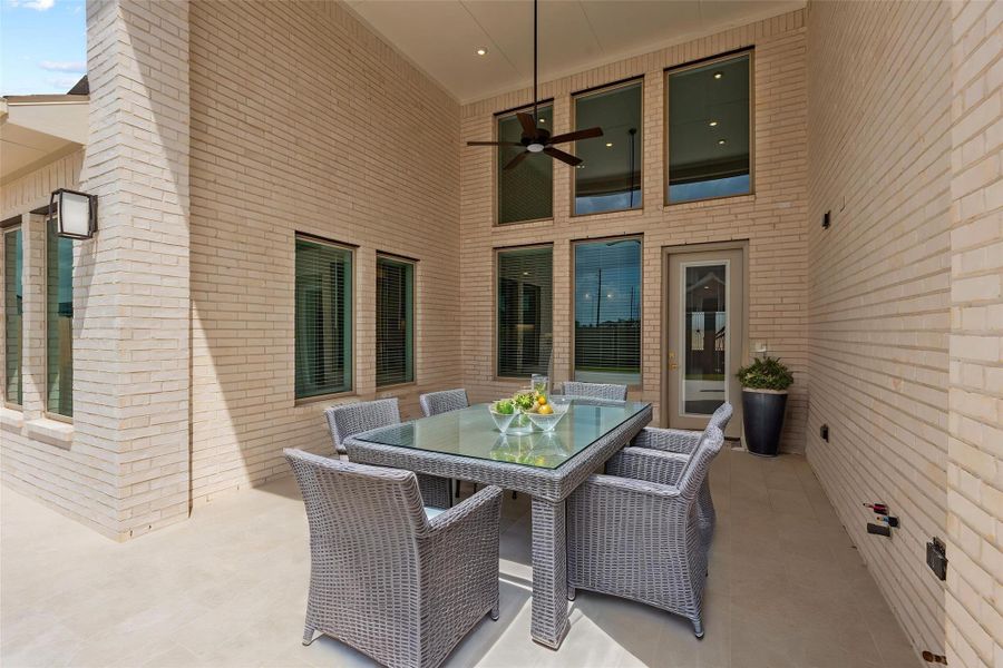 With its soaring covered roofline and custom ceiling fan, this patio space is designed for year-round enjoyment, offering a protected, serene view of the property. Virtually staged.