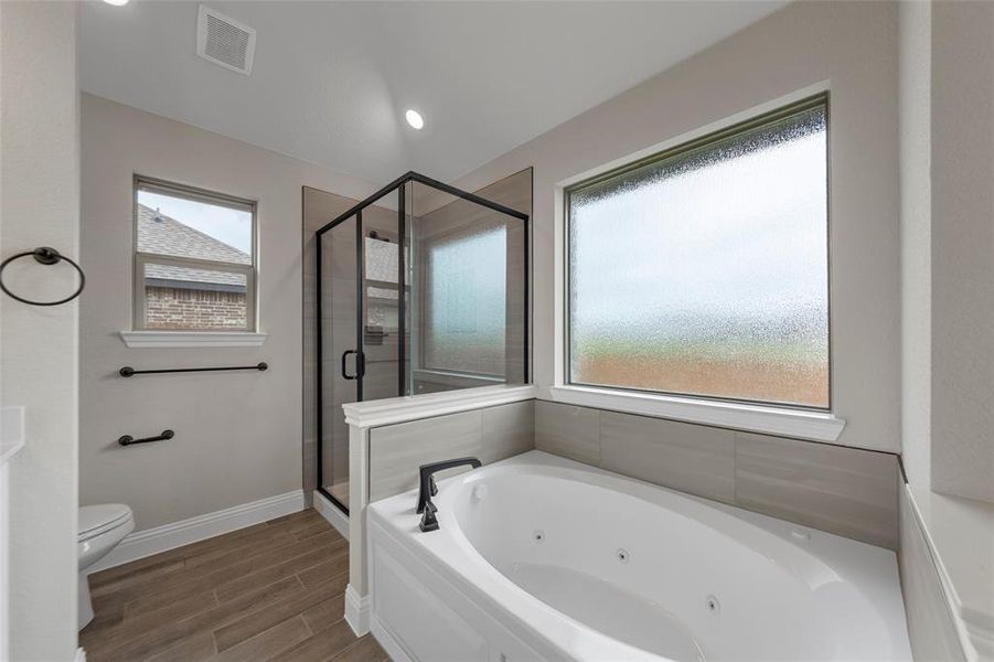 Soaking tub with jetted features and an adjacent glass-enclosed shower
