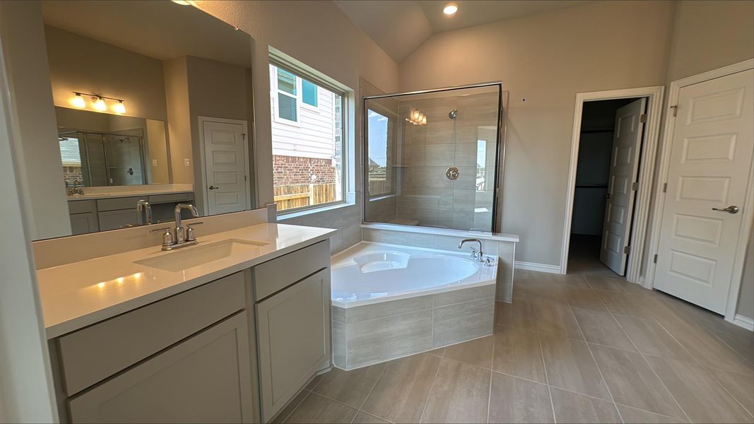 Full bathroom featuring a stall shower, a bath, vanity, light tile patterned floors, and recessed lighting