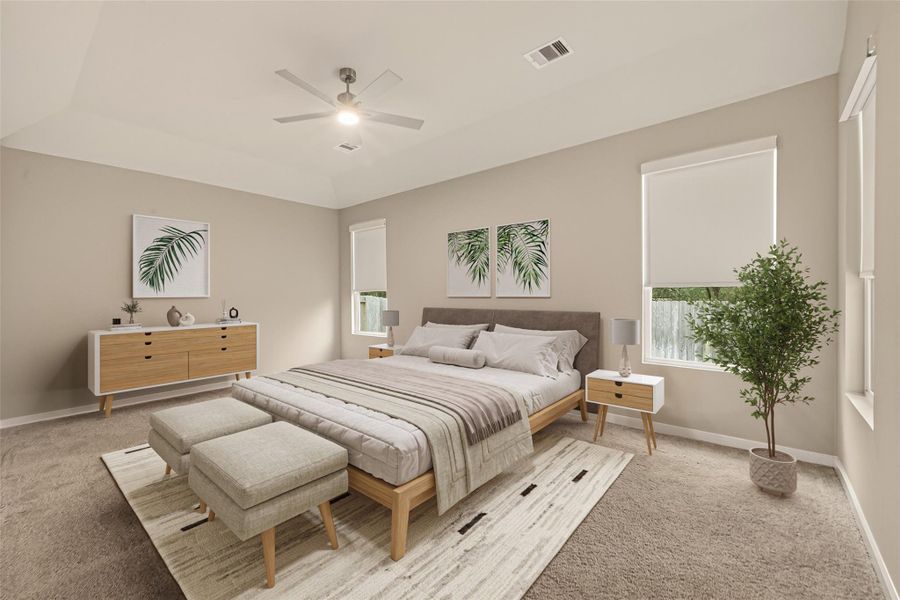 The main bedroom on the first floor features carpeted flooring and windows that provide a view of the backyard. (Virtaully Staged)