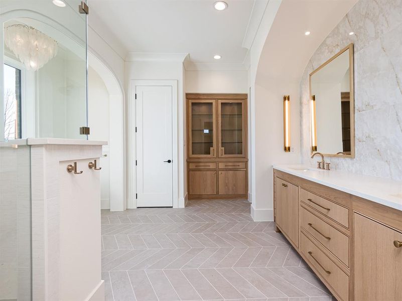 Look at the details in this primary bathroom - hooks for your towels and a gorgeous linen cabinet.