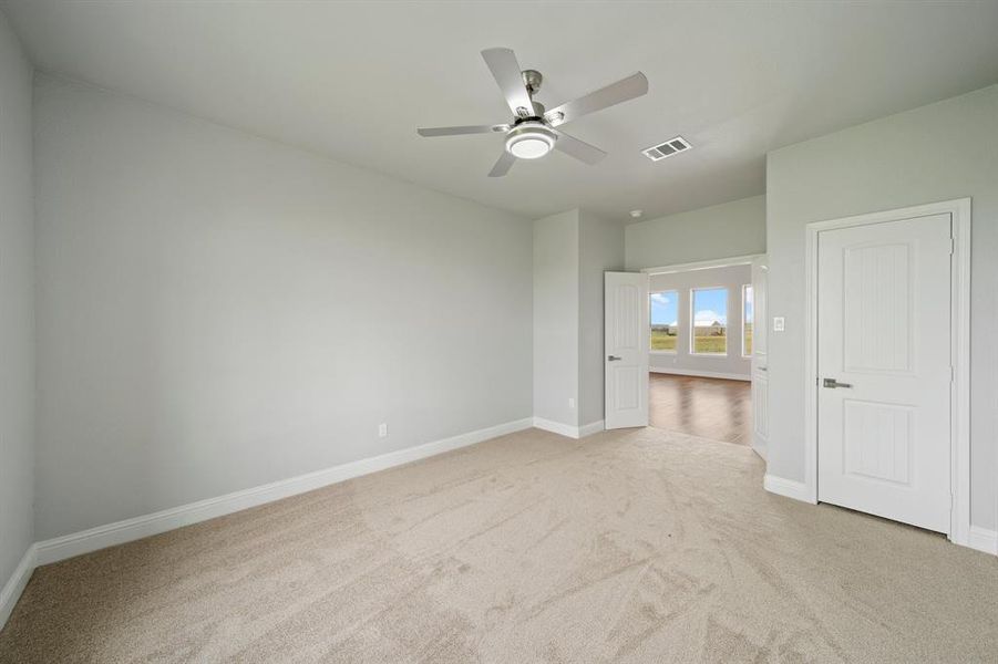 Unfurnished bedroom with light carpet and ceiling fan