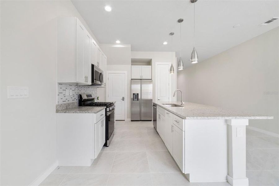 The spacious kitchen allows the family chef to prepare meals with ease surrounded by modern shaker style cabinetry, granite counters, stainless steel appliances that include a GAS STOVE, pantry storage and there is breakfast bar seating on the large island!