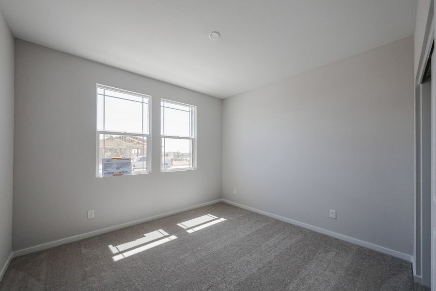 A room with a carpet and a window.