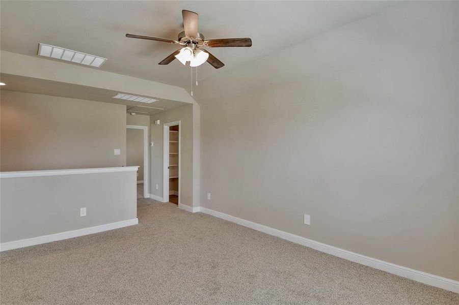 Unfurnished room featuring light carpet and a ceiling fan Unfurnished room featuring light carpet and a ceiling fan