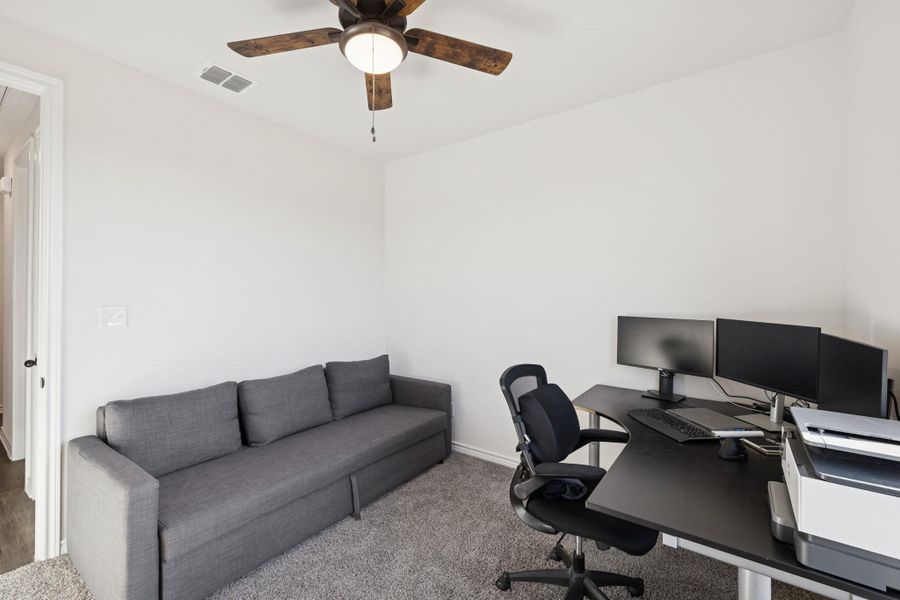 Carpeted office space with a ceiling fan and baseboards Carpeted office space with a ceiling fan and baseboards
