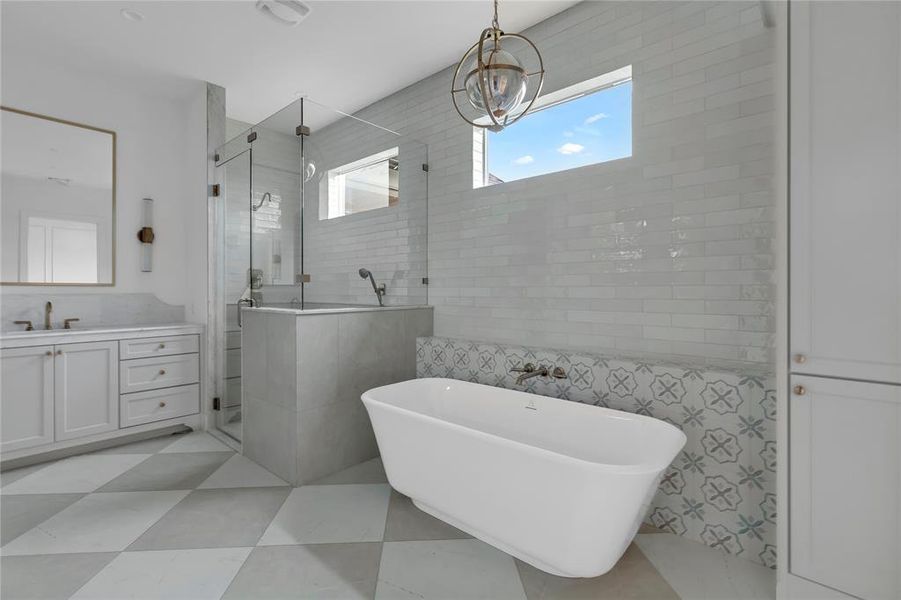 Bathroom with tile walls, vanity, a stall shower, and a freestanding tub