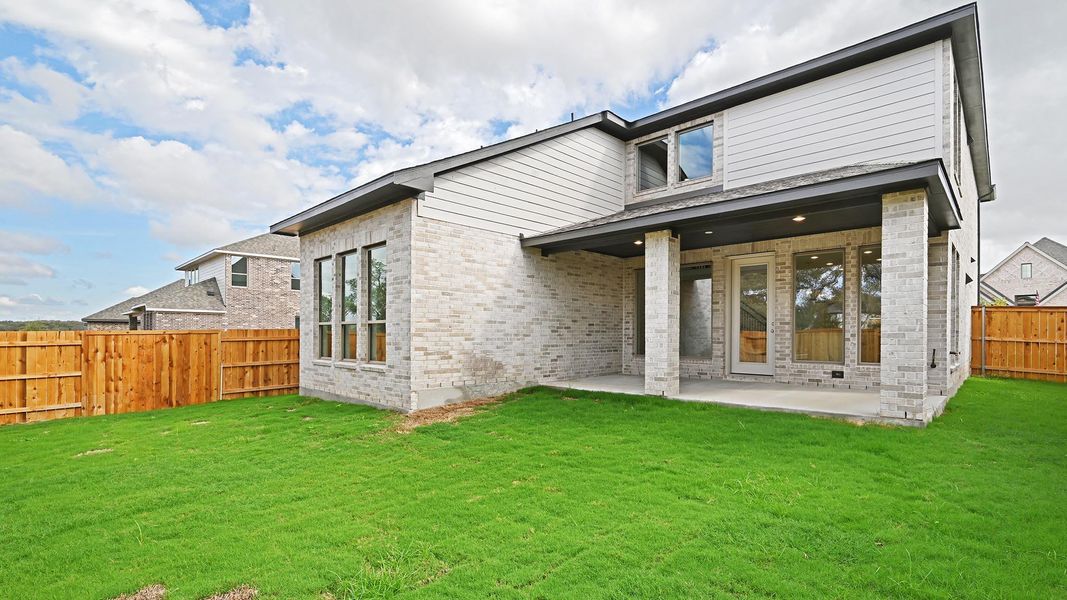 Back of property featuring a fenced backyard, a patio area, and brick siding