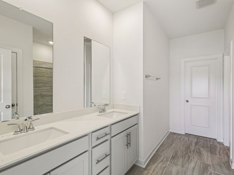 The primary bathroom offers dual vanity sinks and a walk-in shower.