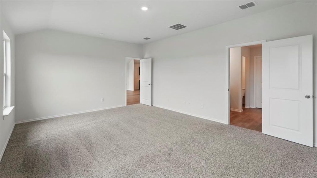 Spacious room with vaulted ceilings and light gray carpeting