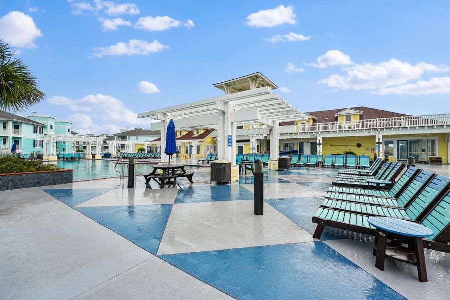 Another view of the community pool highlights its spacious design with plenty of lounge seating for all-day relaxation.