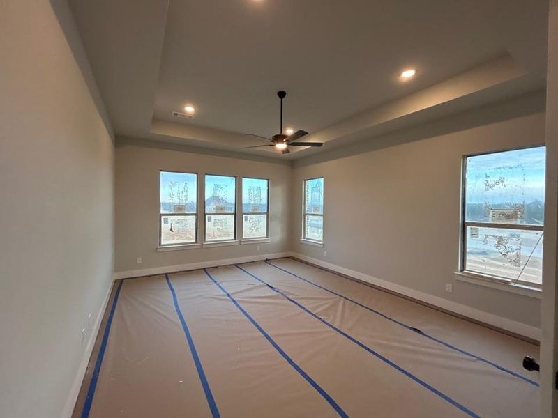 Unfurnished room with a raised ceiling, a ceiling fan, and recessed lighting