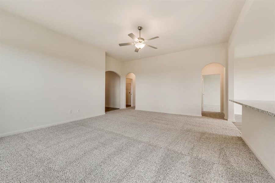 Carpeted empty room featuring ceiling fan