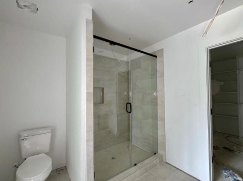 Full bathroom featuring toilet and a shower stall Full bathroom featuring toilet and a shower stall
