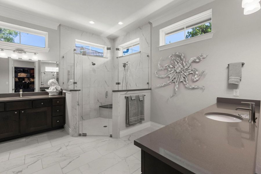 A lavish bathroom with dual vanities and an oversized walk-in shower invites relaxation.
