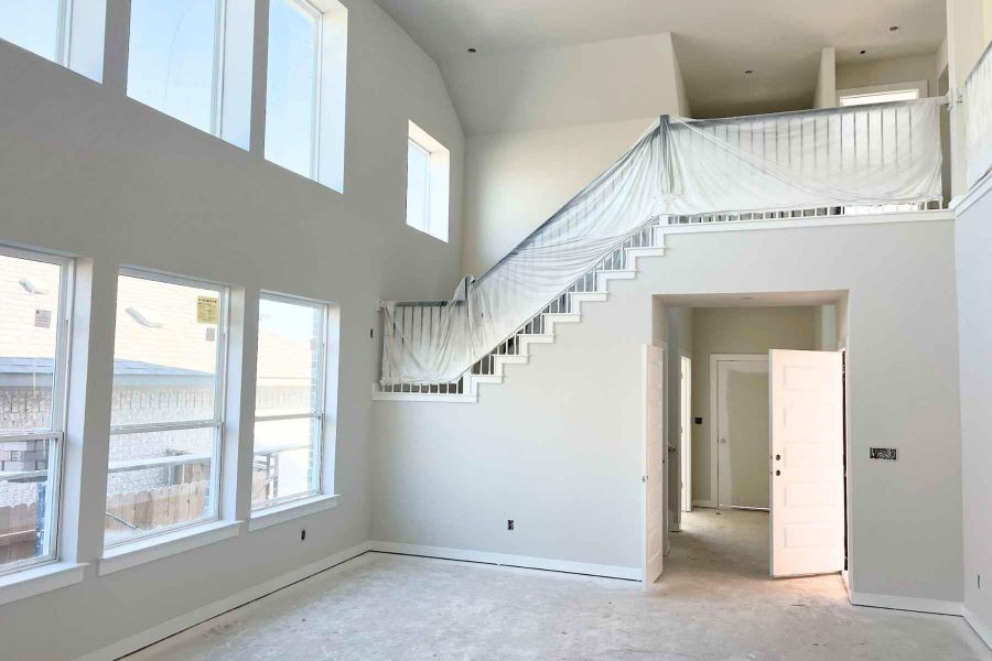 Stairway featuring a high ceiling and unfinished concrete flooring