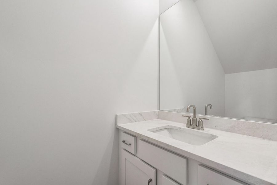White vanity with an integrated rectangular sink, light-toned countertop, and brushed nickel faucet