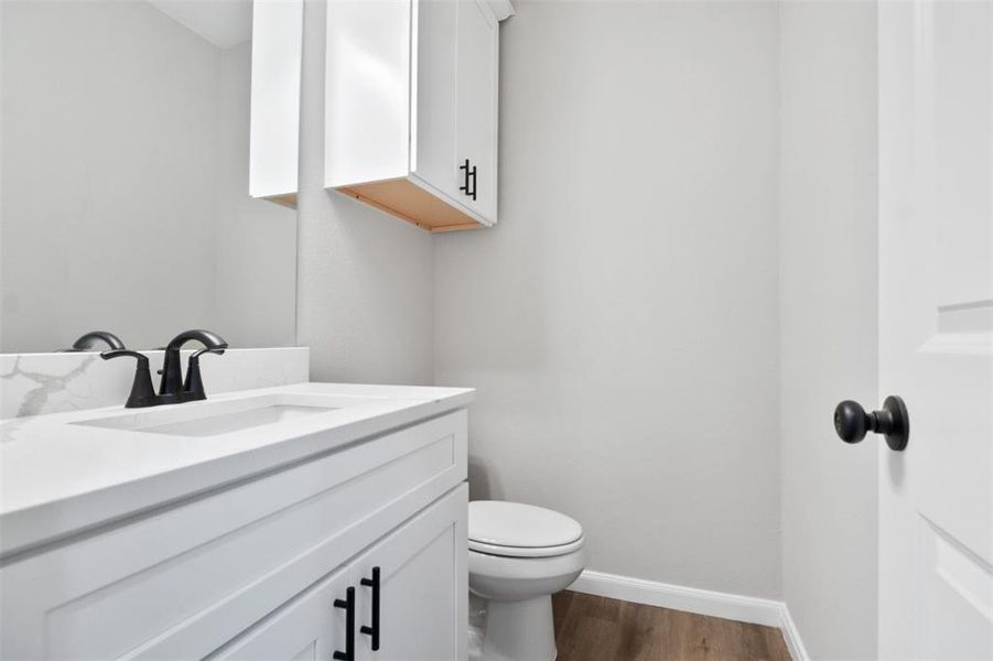 Bathroom featuring toilet, vanity, and hardwood / wood-style flooring