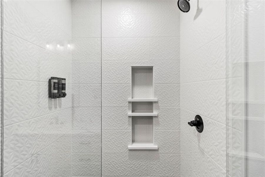 Ensuite bath with geometric tile floor to ceiling with plenty of space