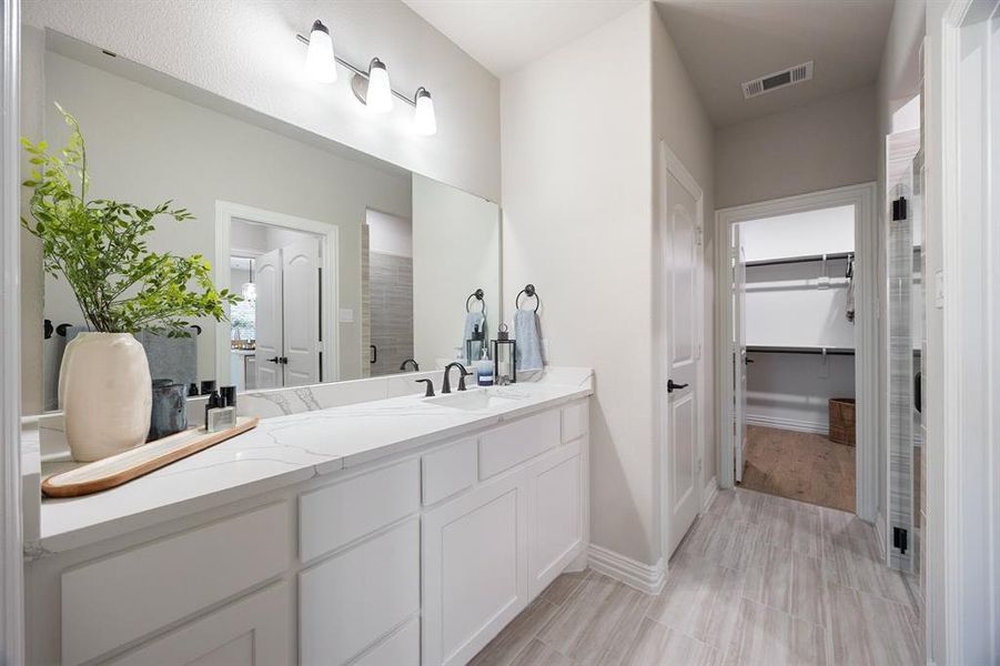 Full bathroom featuring a walk in closet and double vanity