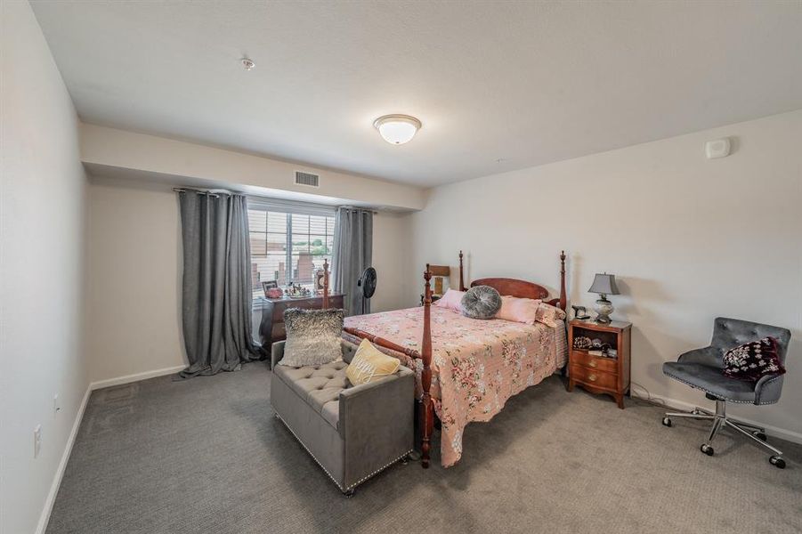 Bright and spacious primary bedroom with neutral tones creating a comfortable retreat with natural light.