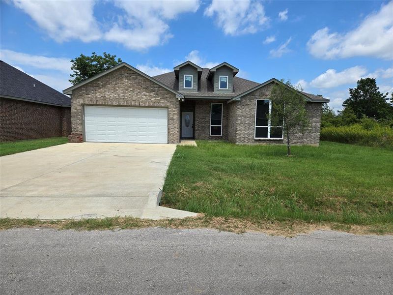 View of front of home featuring a garage and a front lawn