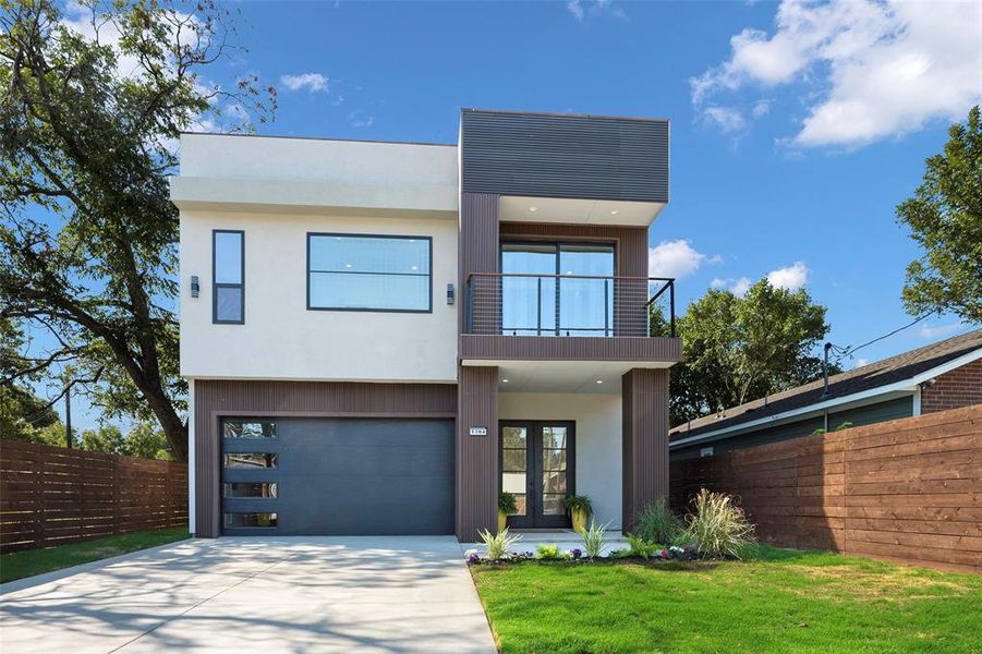 Modern home with a garage, a front lawn, and a balcony