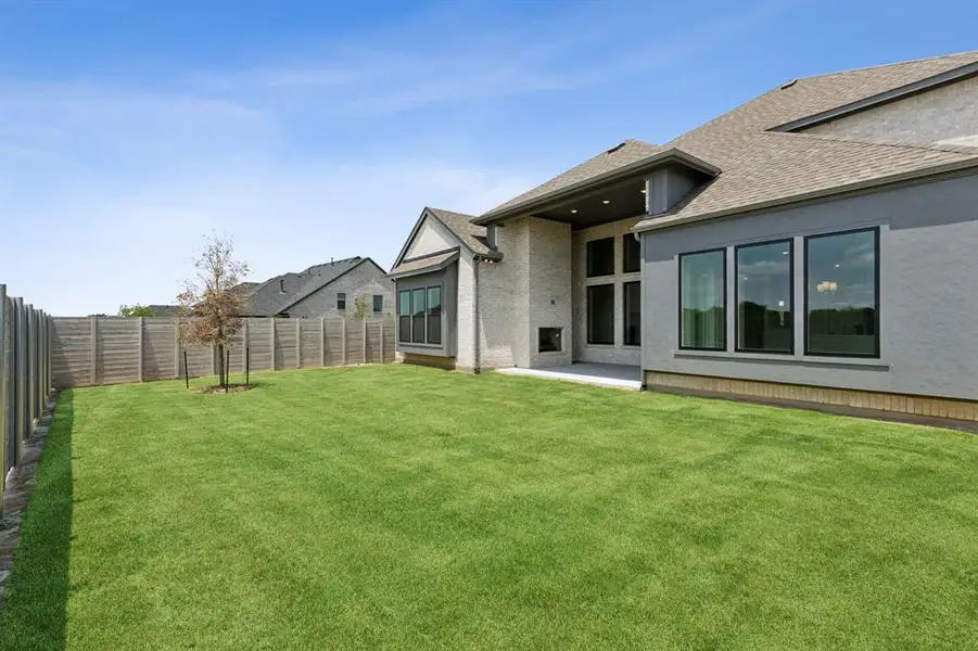 Expansive backyard with a manicured lawn, a full privacy fence, and a concrete patio Expansive backyard with a manicured lawn, a full privacy fence, and a concrete patio