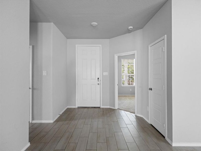 Entryway featuring wood finish floors and a textured ceiling Entryway featuring wood finish floors and a textured ceiling
