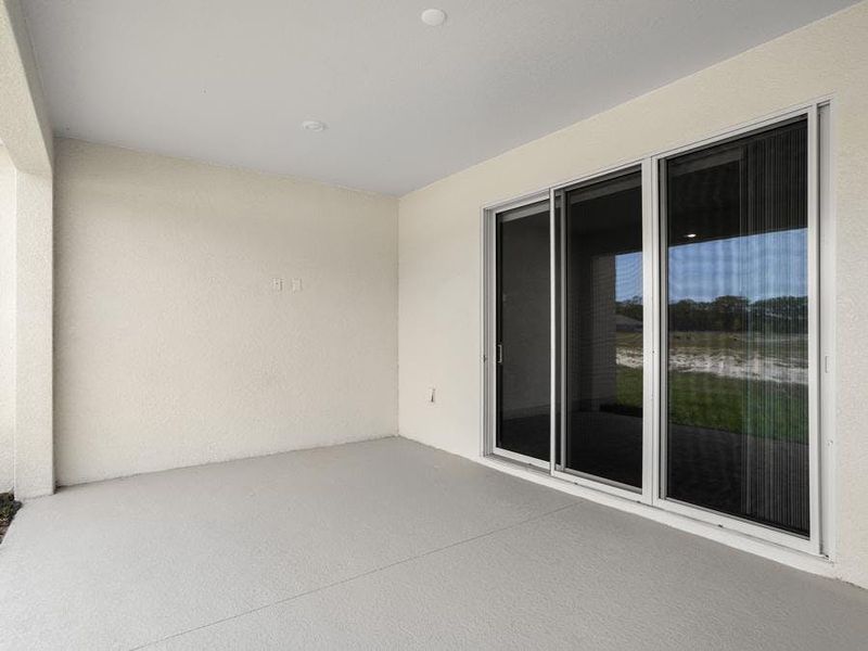 A triple sliding glass door opens to outdoor living space on your covered lanai - Everly by Highland Homes