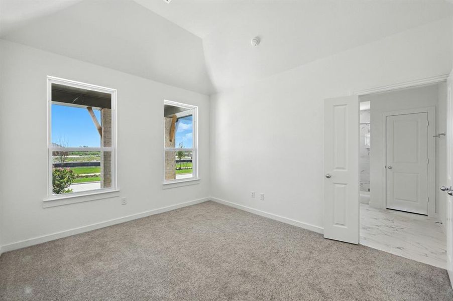 Unfurnished room with light carpet and vaulted ceiling