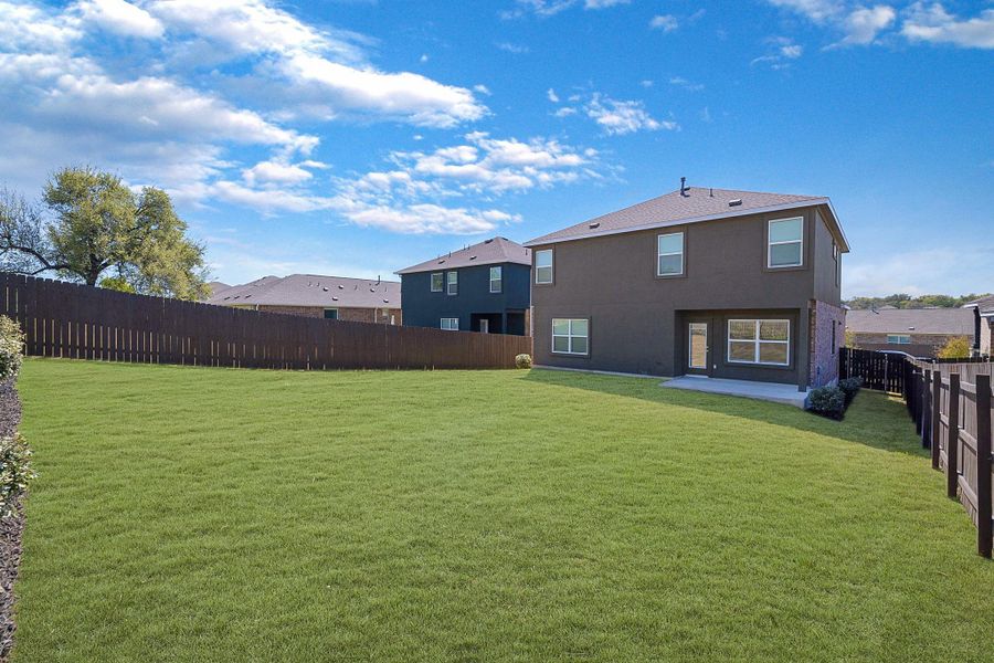 Rear view of house featuring a fenced backyard, a patio area, and stucco siding