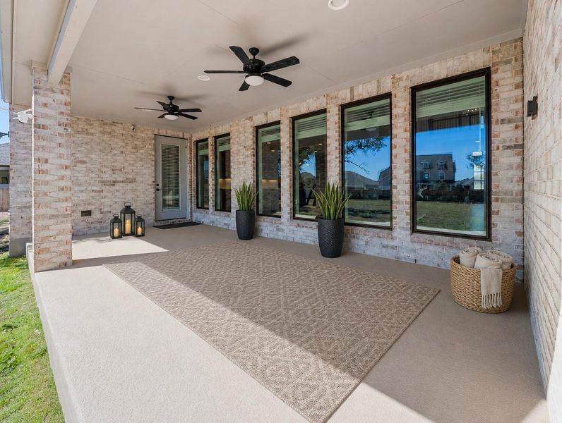 An inviting covered patio features ceiling fans and brick walls, perfect for outdoor relaxation. An inviting covered patio features ceiling fans and brick walls, perfect for outdoor relaxation.
