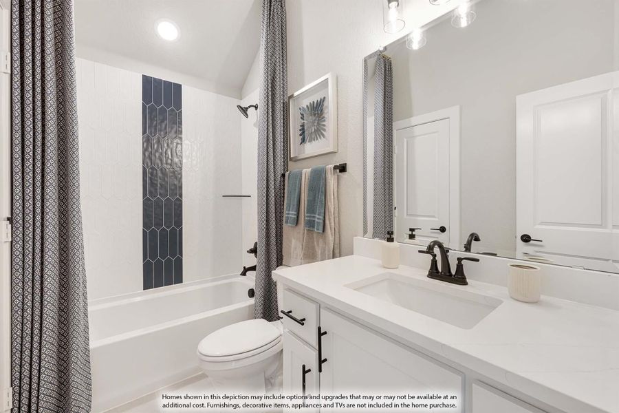 Bathroom with white vanity, tub-shower combo with navy tile accent, and vaulted ceiling